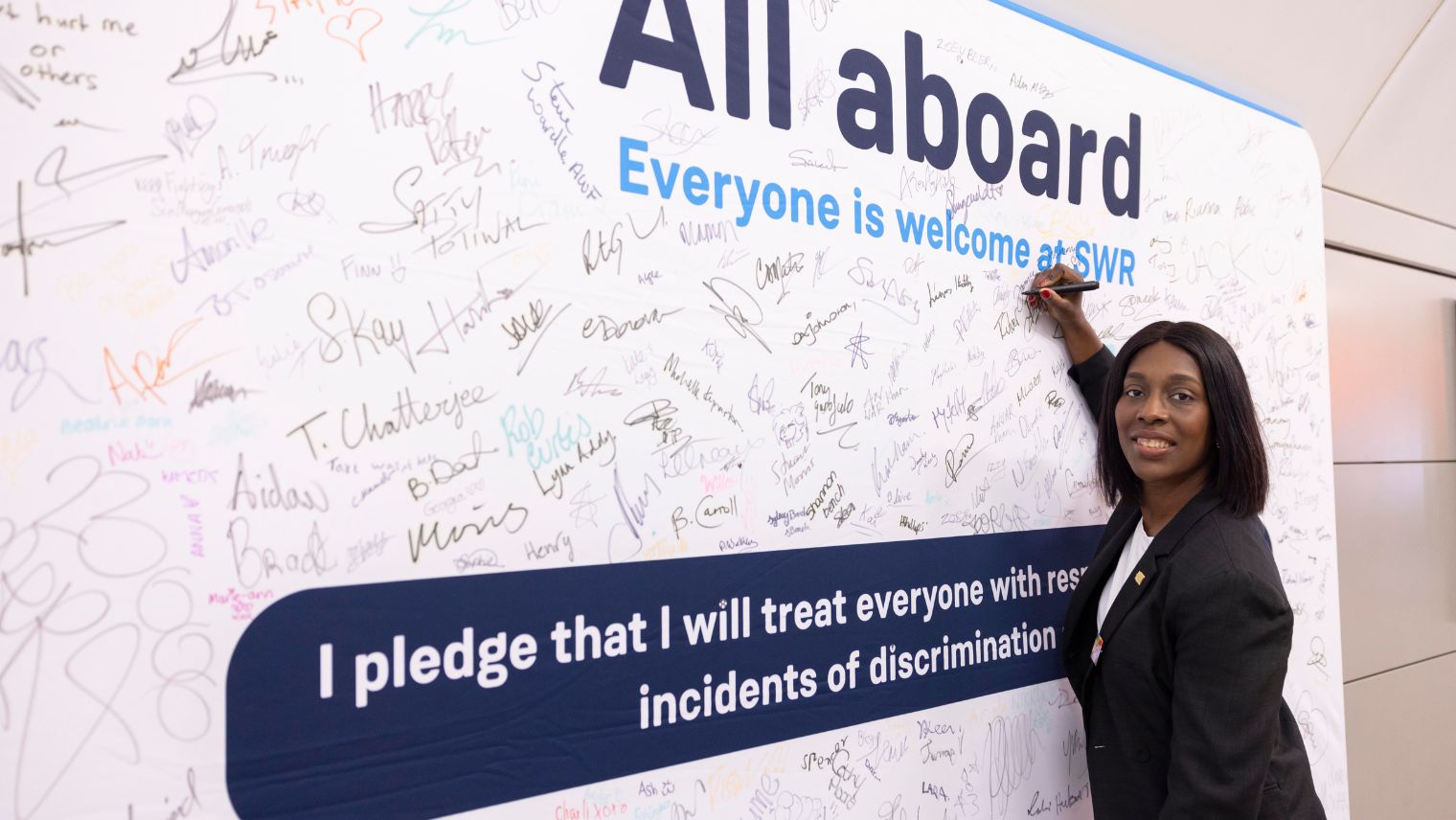 Woman signing a large banner full of signatures