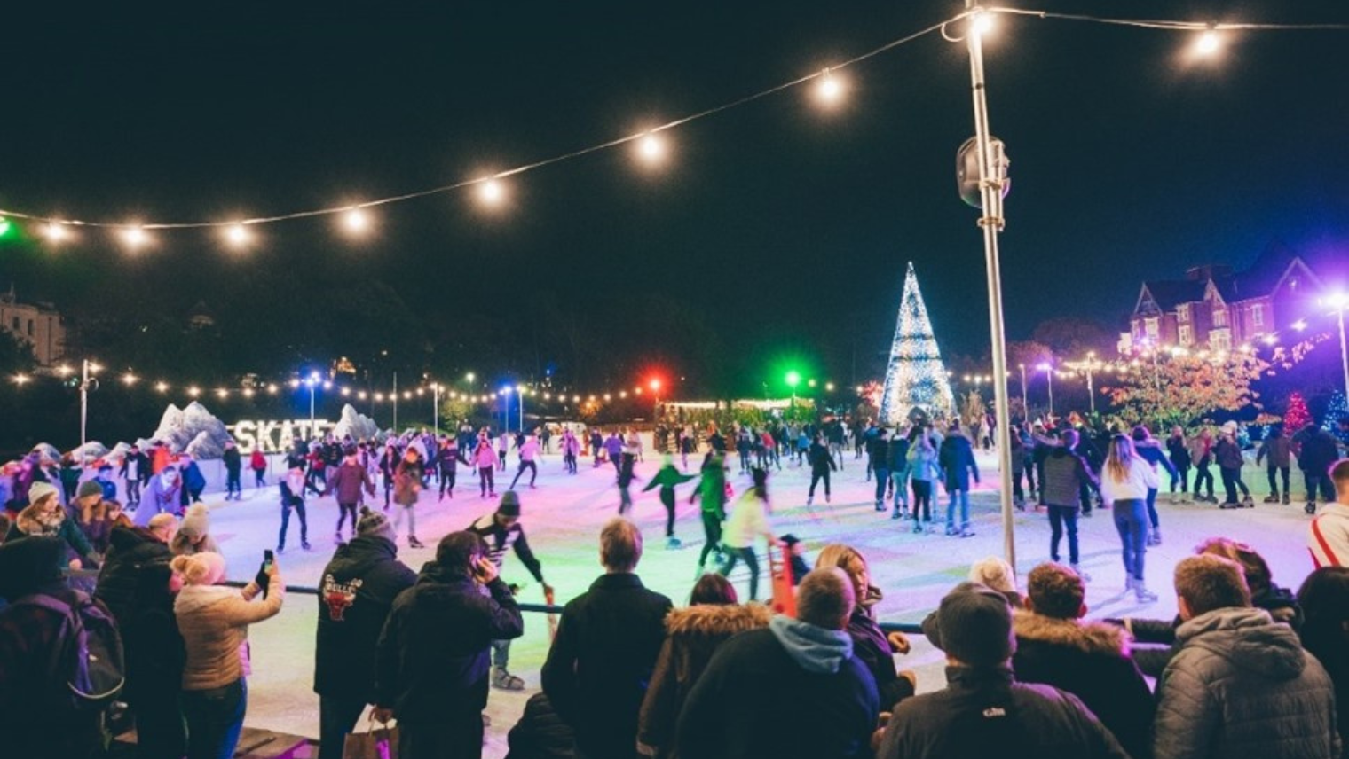 A group of people skating on an ice rink