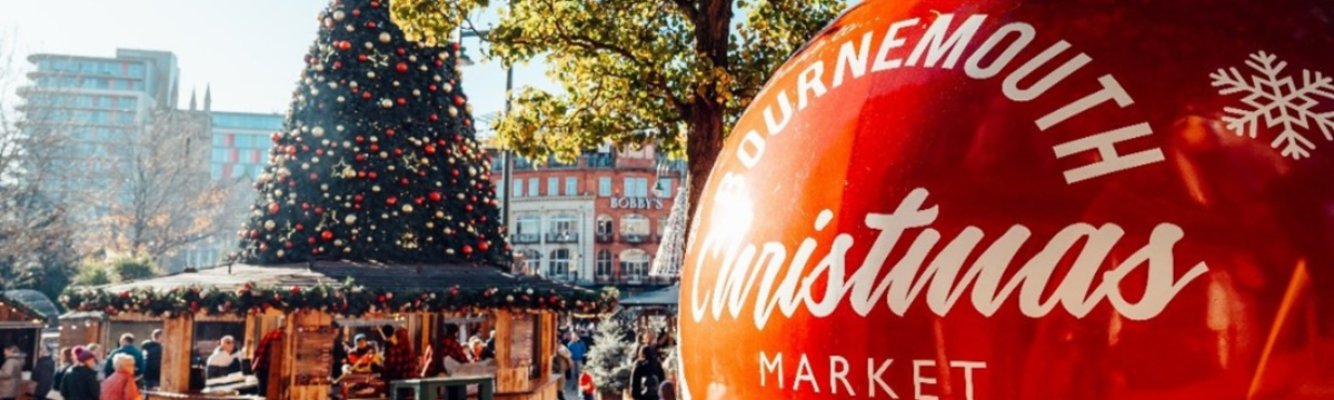 A giant Christmas bauble beside a Christmas tree  