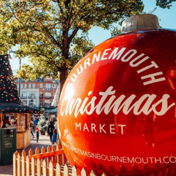 A giant Christmas bauble beside a Christmas tree  