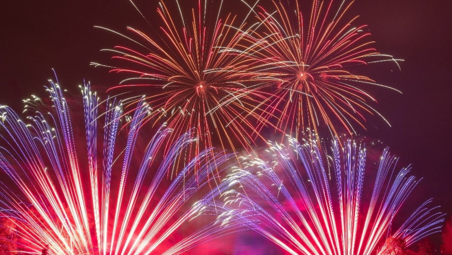 Large fireworks display with a big crowd watching