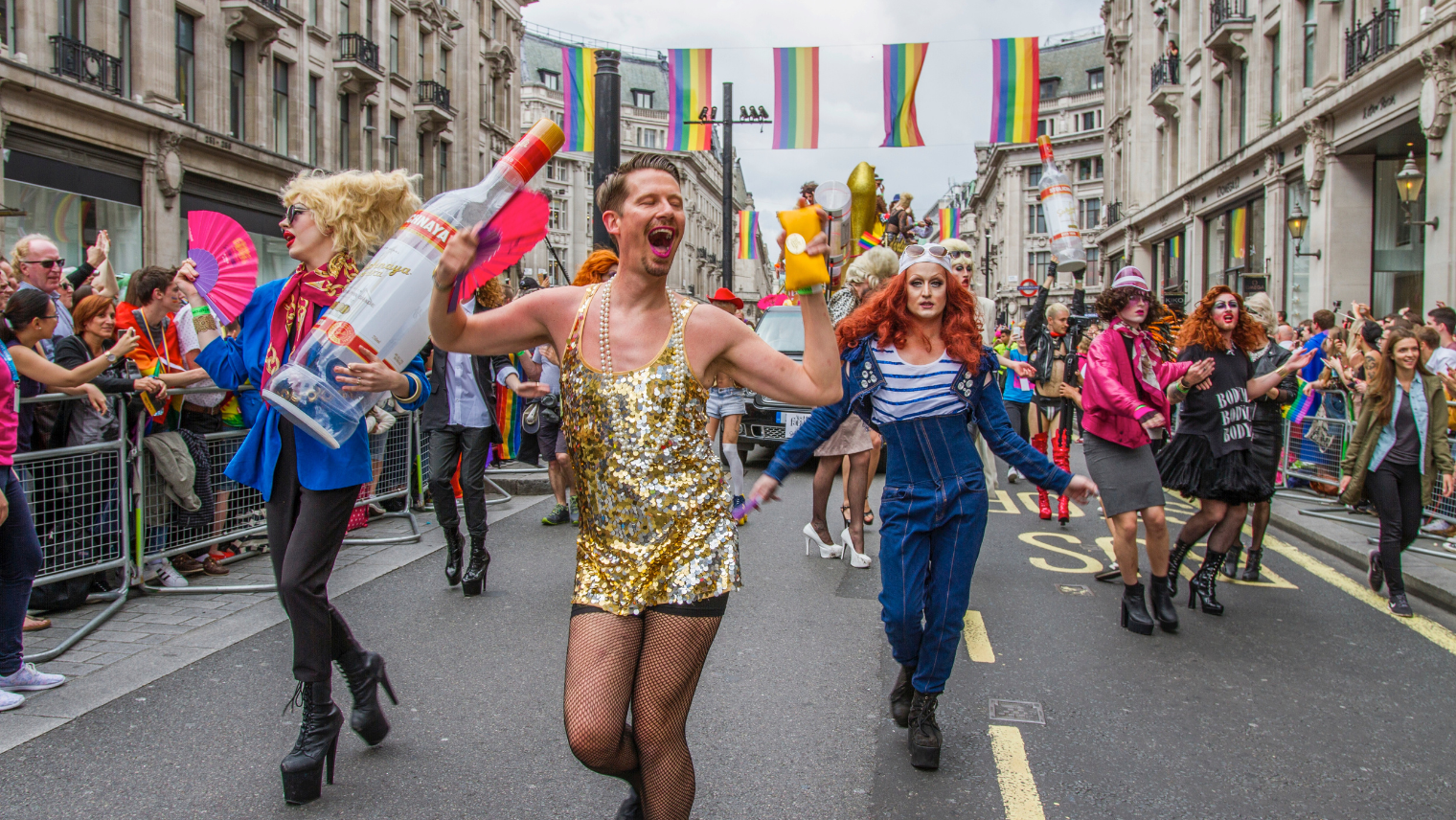 Image of a large crowd at a Pride event marching the streets in colourful clothing