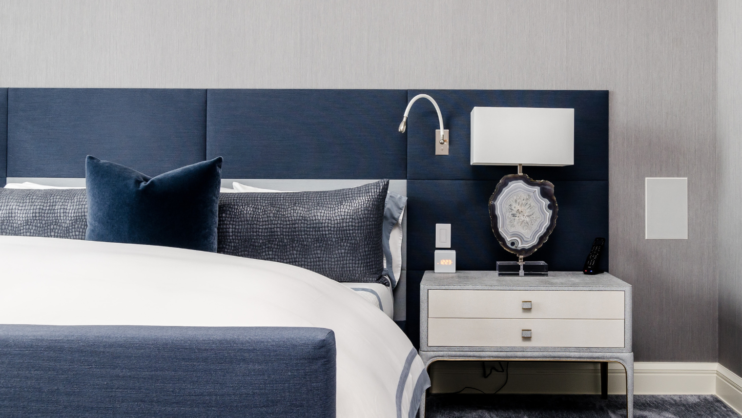 Image of a bed and bedside table at a hotel