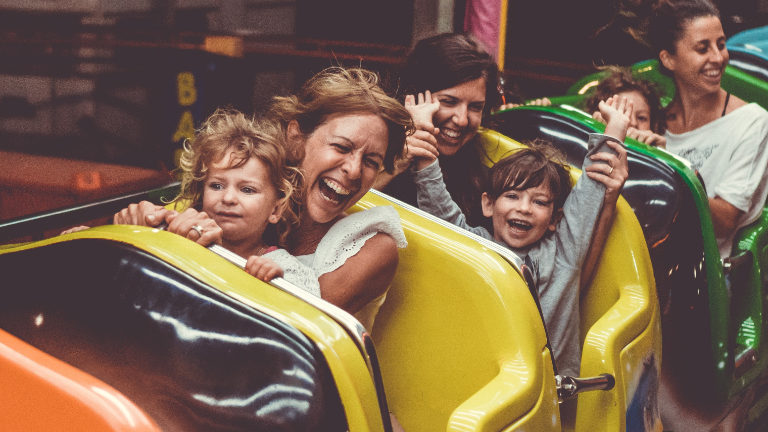 Adults on a theme park ride with kids