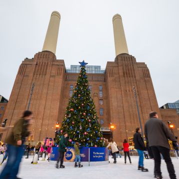 Battersea power station with people iceskating in the foreground of the picture 