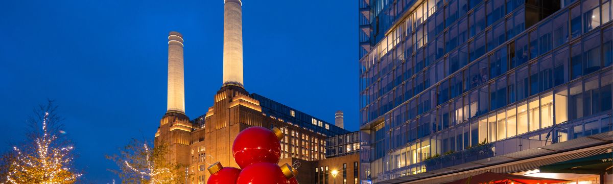 Battersea power station with people giant babbles located near by the entrance 