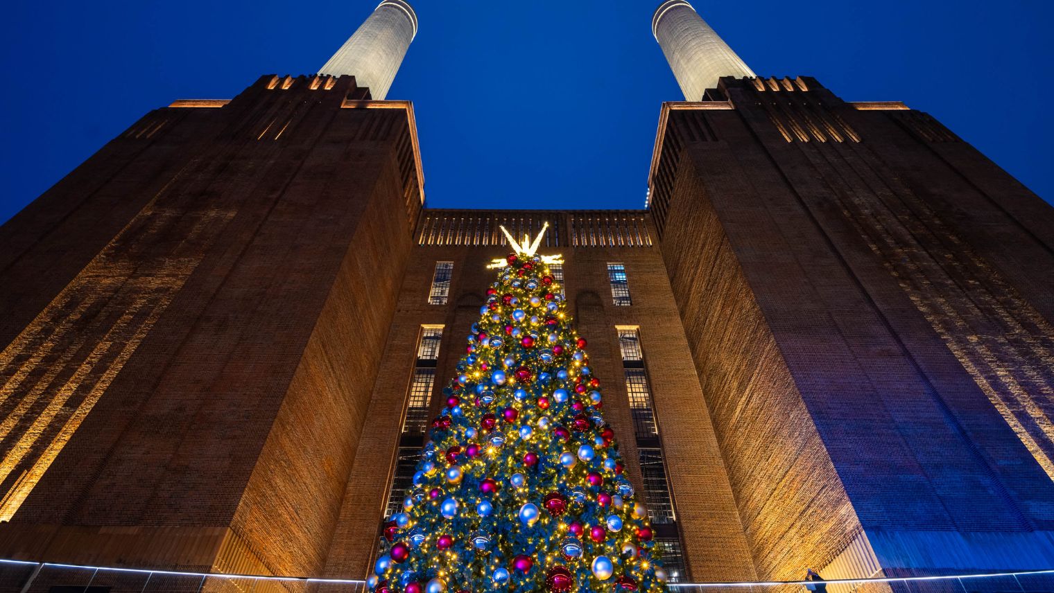 Exterior image of Battersea power station towers with Christmas tree in the foregroond