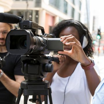 Women behind camera and film crew in the street 