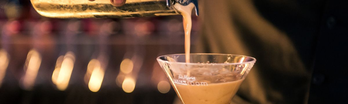 Liquid flowing from a cocktail shaker to a cocktail glass