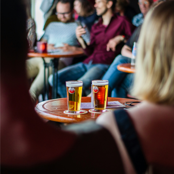 couple sit at the table with a couple of beers