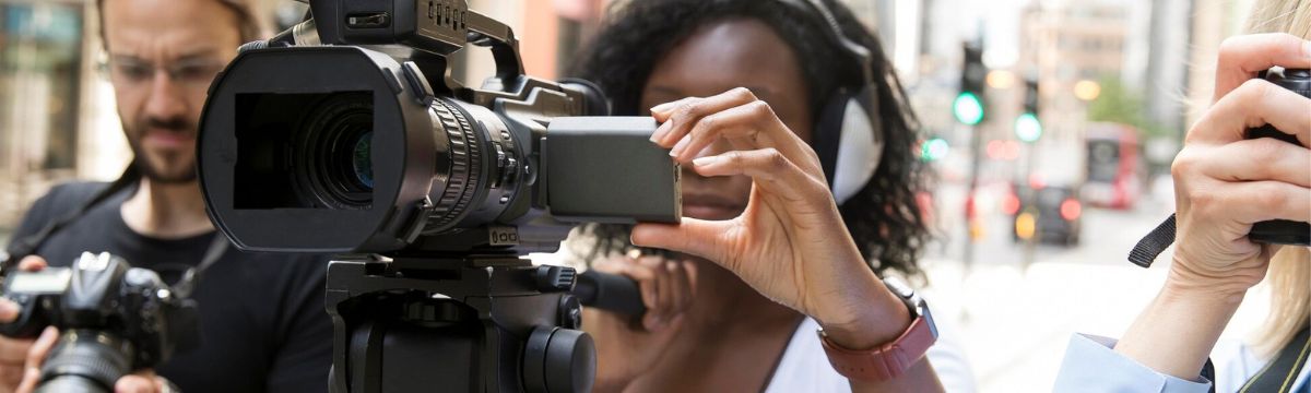 A photo of a female camera operator in the street