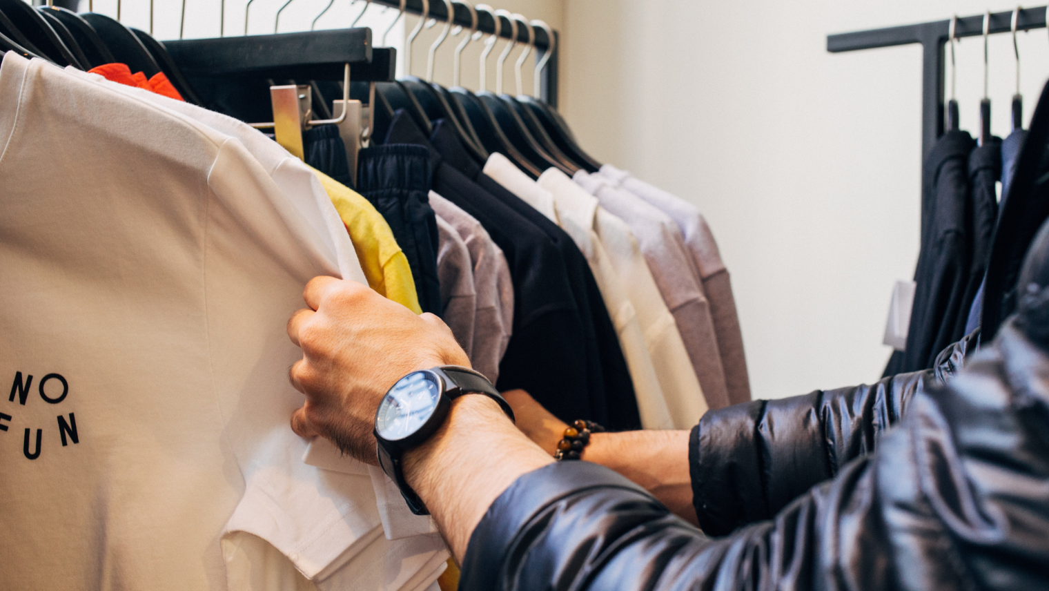 A person looking through clothes rails at a store